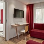 Select Green Hotels Olive Green Heraklion Zimmer mit Sofa und roten Gardinen