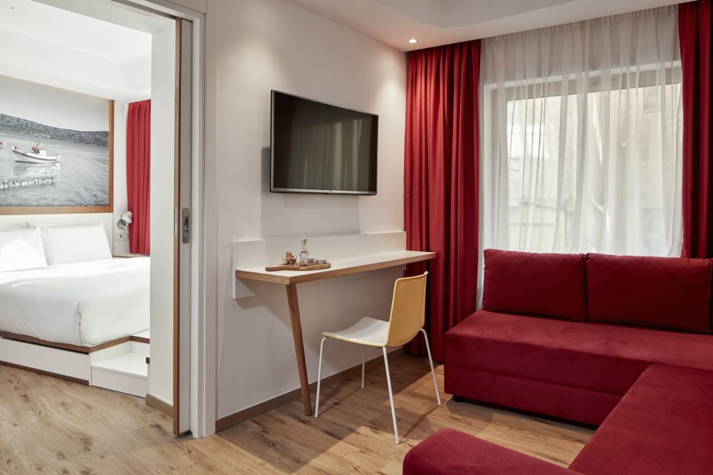 Select Green Hotels Olive Green Heraklion Zimmer mit Sofa und roten Gardinen