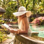 LUX* Le Morne woman with book and hat in pool